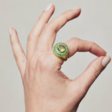 image of firework statement ring in green and gold on a hand with thumb and forefinger making circle