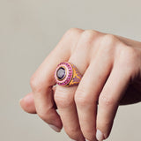 image of statement firework ring in pink, purple and gold on hand with fingers curled downwards