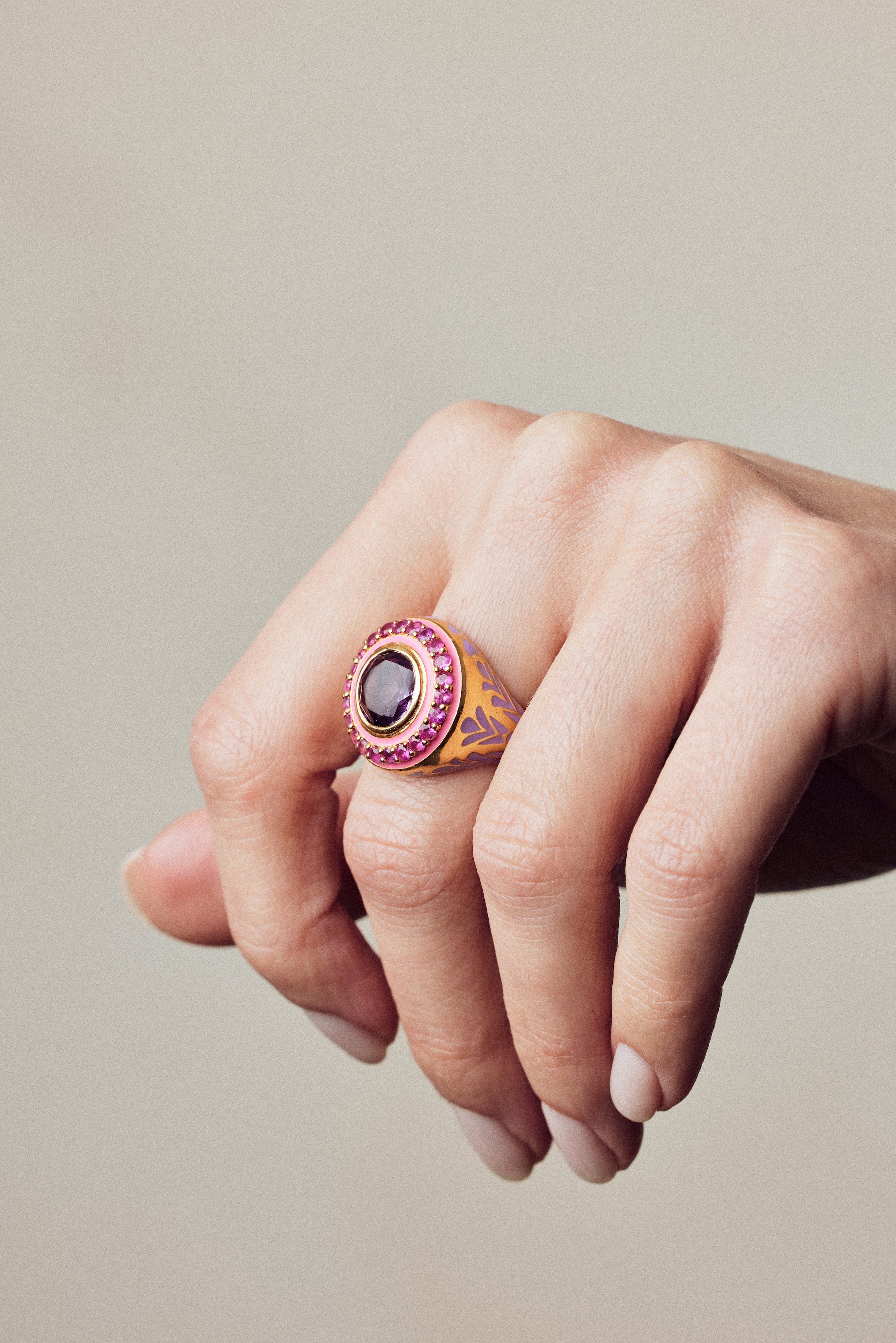 image of statement firework ring in pink, purple and gold on hand with fingers curled downwards