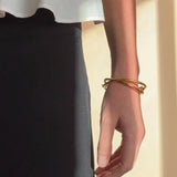Ruddock-Soma-Bangle-Cuff-Interlocking-Interwoven-Tublar-Scultpural-twisted-clean-lines-forms-modern-statement-bracelet-Sleek-minimal-cool-jewellery-demifine-gold-plated-18ct